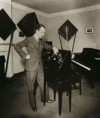 Lev Termen standing infront of custom theremin in an RCA Theremin cabinet with five ca. 1926 - 28 National 