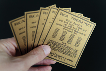 Hand holding 4 replica RCA Theremin License Notices